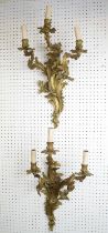 WALL LIGHTS, a pair, Louis XV style Rococo design gilt metal, three branch, 60cm H x 35cm. (2)