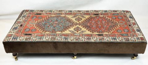 HEARTH STOOL, 33cm H x 168cm W x 83cm D, carpet and brown velvet upholstered, on brass castors.