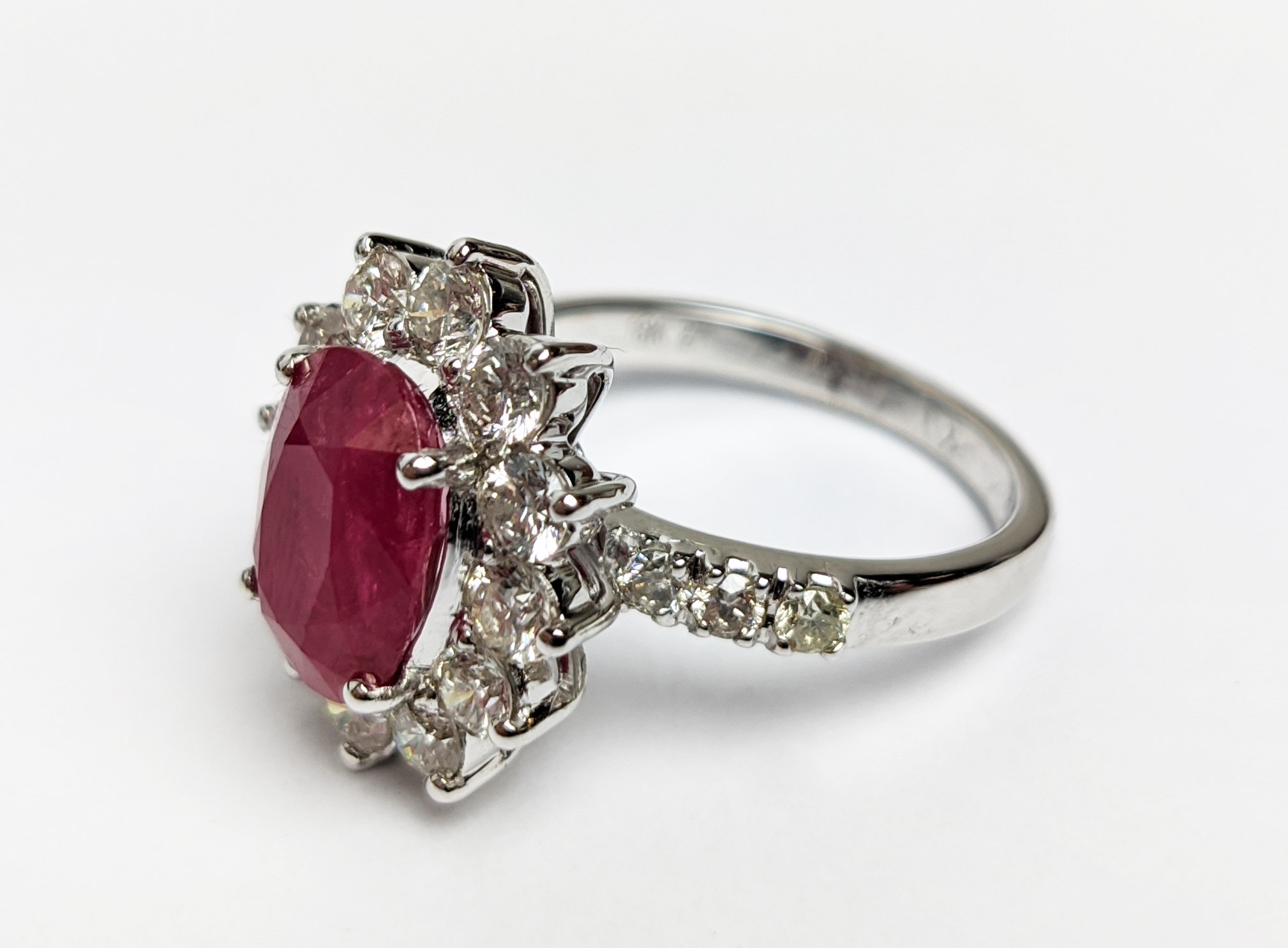 AN 18CT WHITE GOLD RUBY AND DIAMOND CLUSTER RING, with diamond set shoulders, the central oval cut - Image 7 of 10