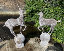 SCULPTURAL STAGS, a pair, 100cm high, 60cm wide, cast metal, on globular bases. (2)