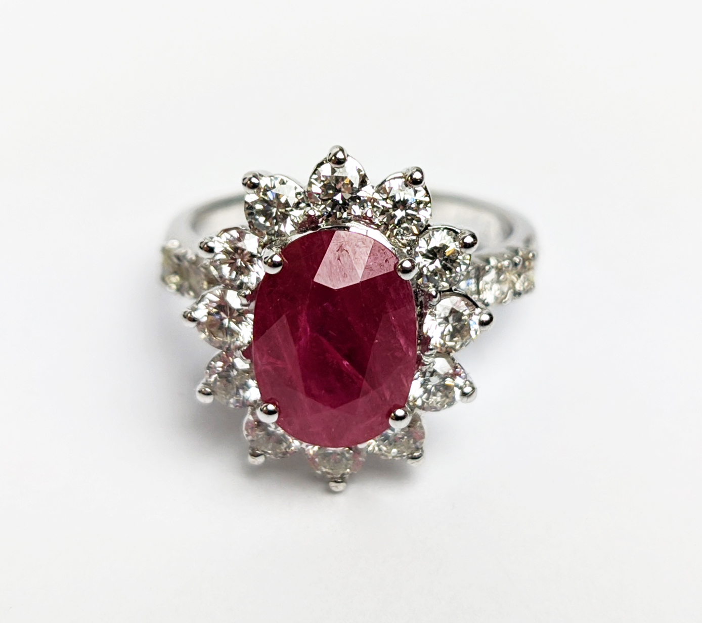 AN 18CT WHITE GOLD RUBY AND DIAMOND CLUSTER RING, with diamond set shoulders, the central oval cut - Image 4 of 10