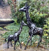 SCULPTURAL GIRAFFES, two, painted metal, a larger giraffe measuring 152cm high x 120cm long x 25cm