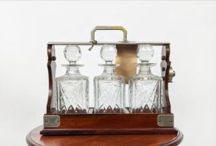 MAPPIN AND WEBB TANTALUS, early 20th century mahogany with three cut glass decanters with key,