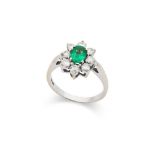 An emerald and diamond cluster ring