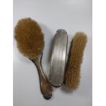 A ladies three-piece silver hair brush set.