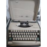 An Olympia De Luxe typewriter in a zipped case.