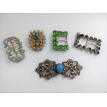 A collection of five belt buckles.