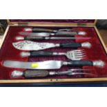 A cased canteen of silver-plate: two pairs of carvers, a fish knife and fork, and a steel, all