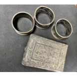 Three sterling silver napkin rings and an Asian silver coloured metal filigree cigarette case.