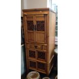 An Oriental cupboard. 20th century. With a pair of openwork doors.