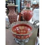 Two Oriental vases and a bowl in the style of Bencharong with printed designs on brick red ground