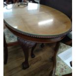 A Mahogany Dining Table, circa 1930. Carved with gadroon border with a glass cover and an extra