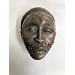 A West African Bronze mask. 19th century. probably a ceremonial female head. With platted hair and