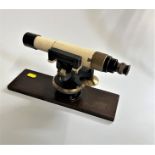 A vintage brass surveyors Land telescope, with a stained wood box