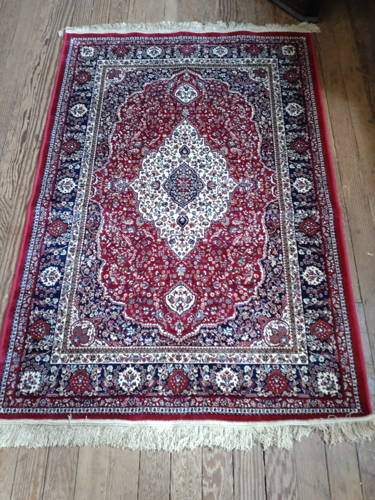 A red ground full pile Kashmir rug with traditional floral medallion design (170cm x 120cm)