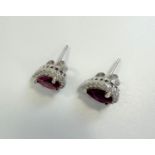 Pair of silver cluster studs set with pear-shaped red cubic zirconia