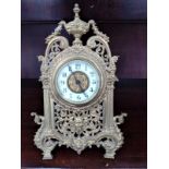 French timepiece c 1880. In brass ornate case. The white chapter ring with arabic numerals.