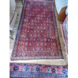 Red and blue ground Iranian village rug, all over design. 200cm x 105cm.