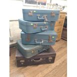 A collection of five vintage suitcases.