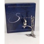 A silver moon silver sculpture of a bird in a bush with original box.