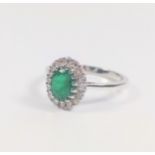 18ct white gold oval emerald and diamond cluster ring. Emerald 1.31ct. RBC diamonds 0.37ct. Size