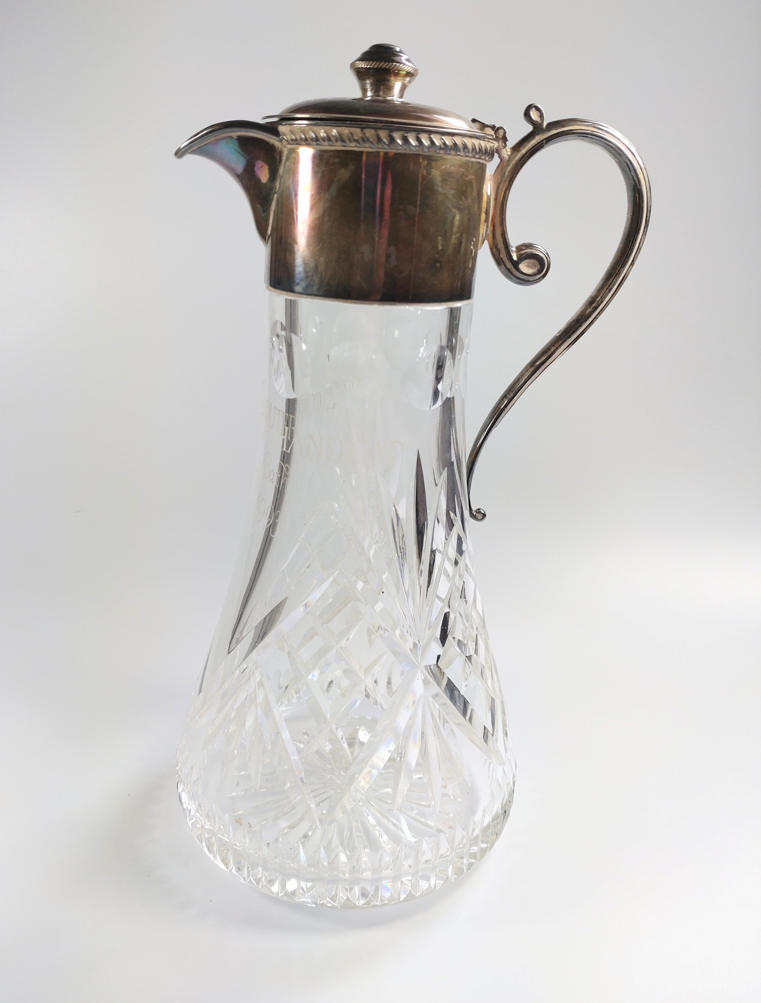 A silver plated mounted cut glass claret jug. Inscribed. 28cm high.