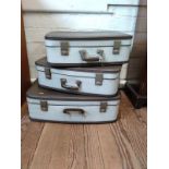 A set of three vintage suitcases.