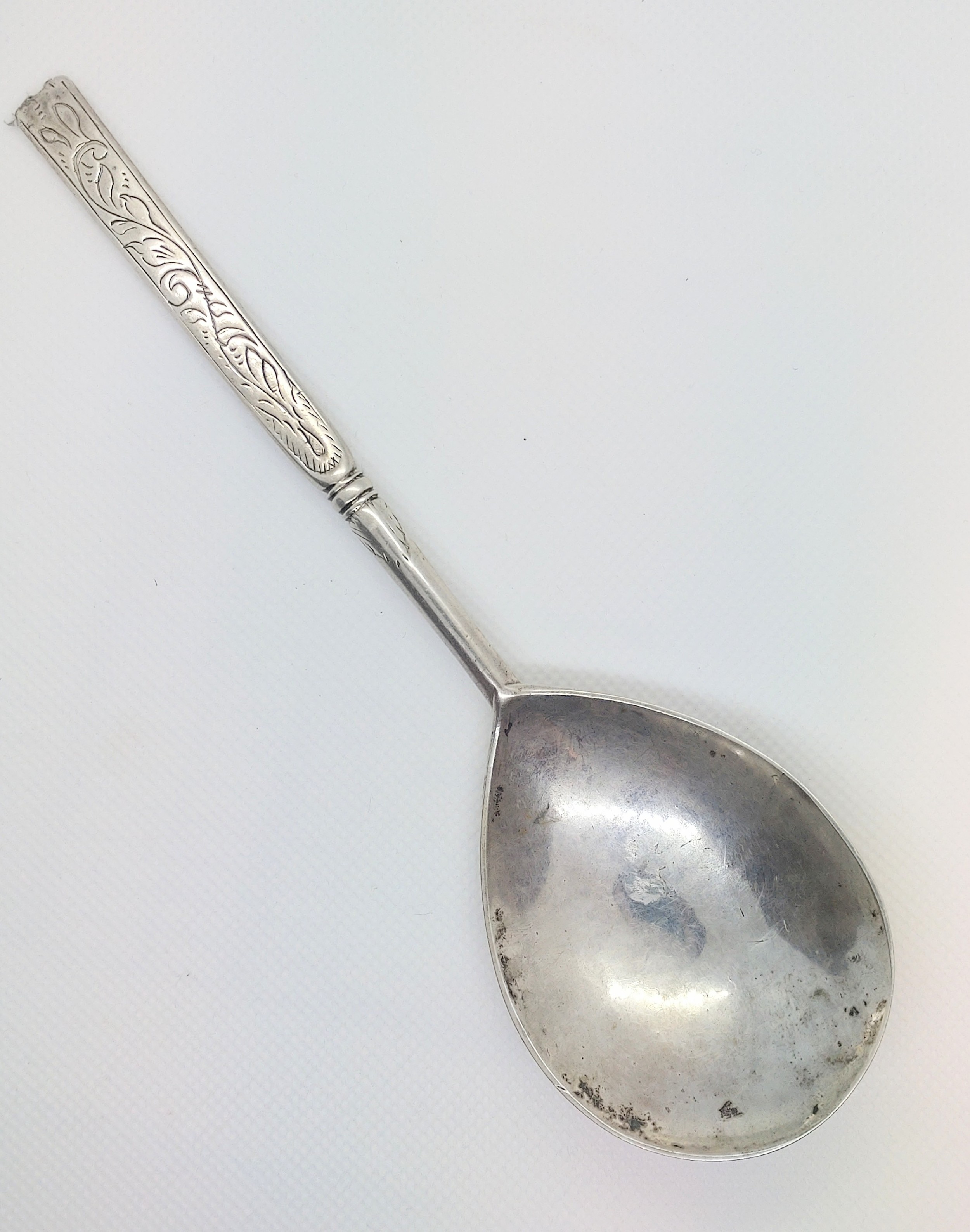 An 18th century Scandinavian silver spoon engraved with scrolling foliage and groups of initials.