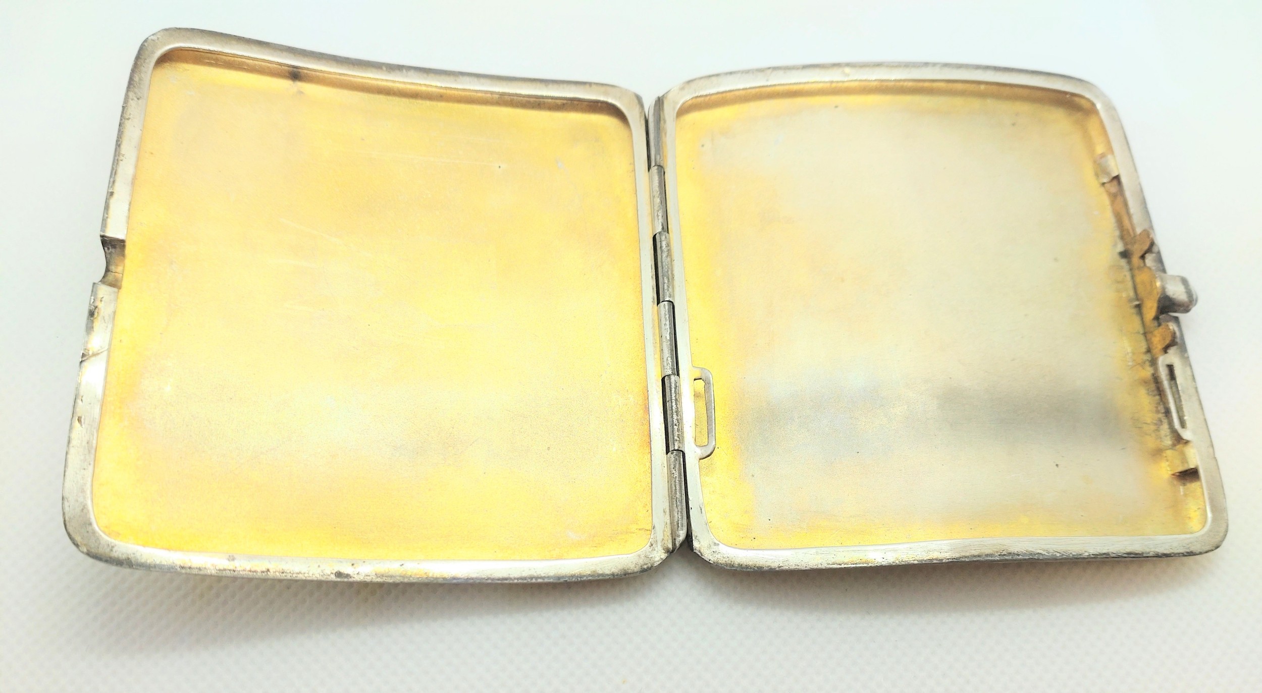 A sterling silver cigarette case with gold pique decoration, apparently unmarked. 8.5cm wide. - Image 2 of 2