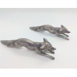 A pair of cast silver coloured metal foxes. Unmarked circa 1900. 8.5cm long, 132 gms.