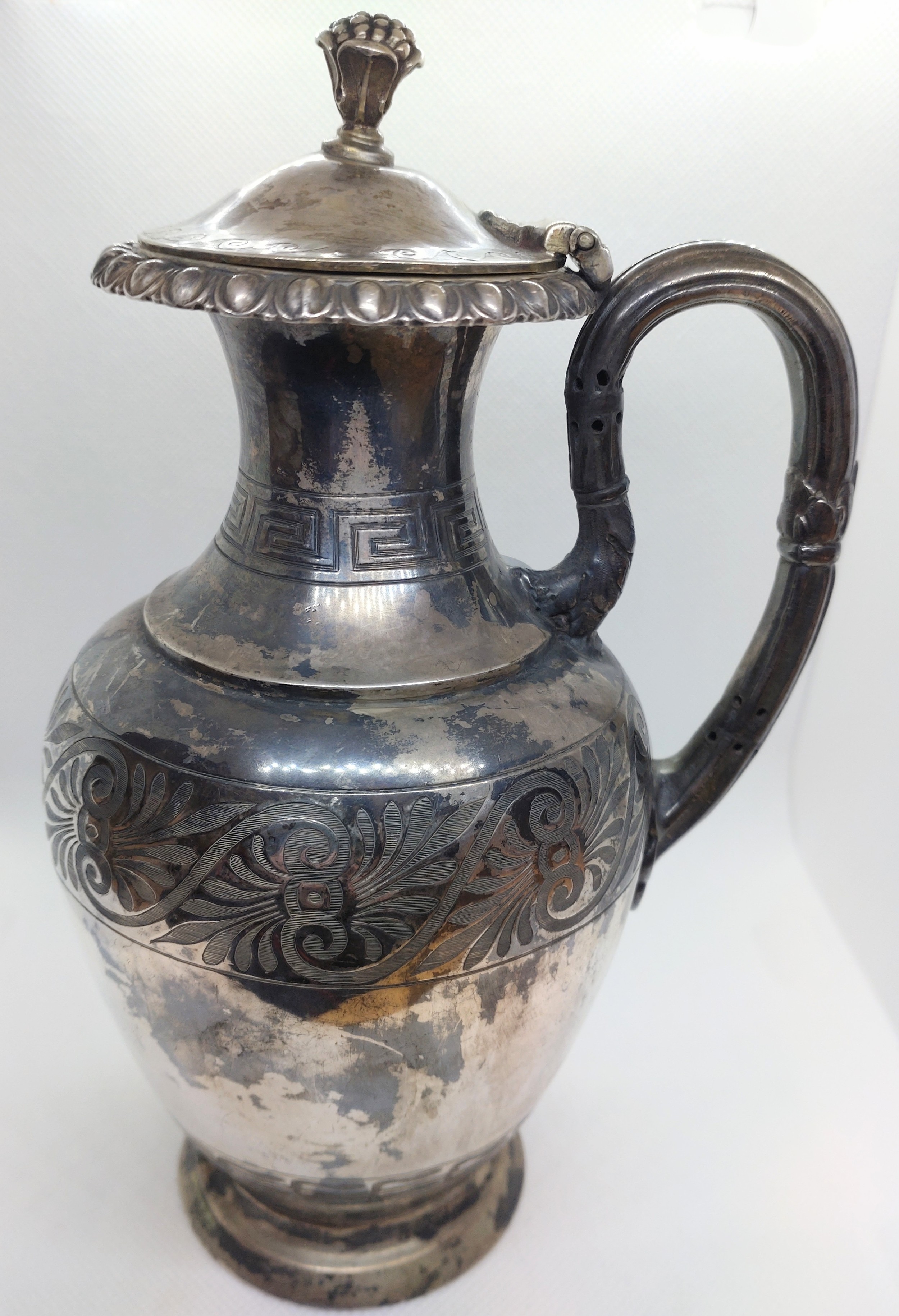 A Victorian sterling silver jug. London 1859. With Grecian design borders. Pomegranate finials. 21cm