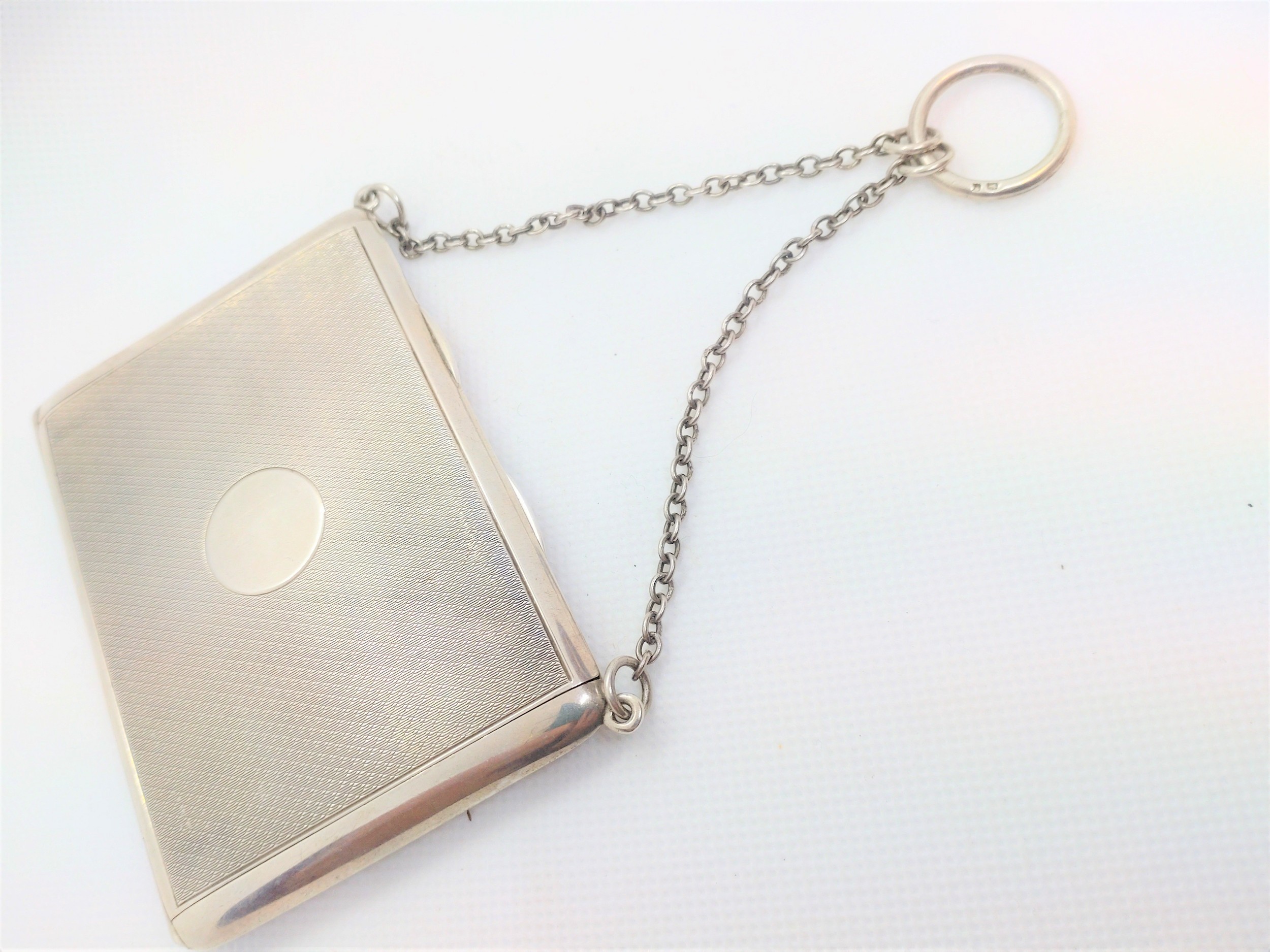 An engine turned sterling silver calling card case. London 1919. With silk interior.