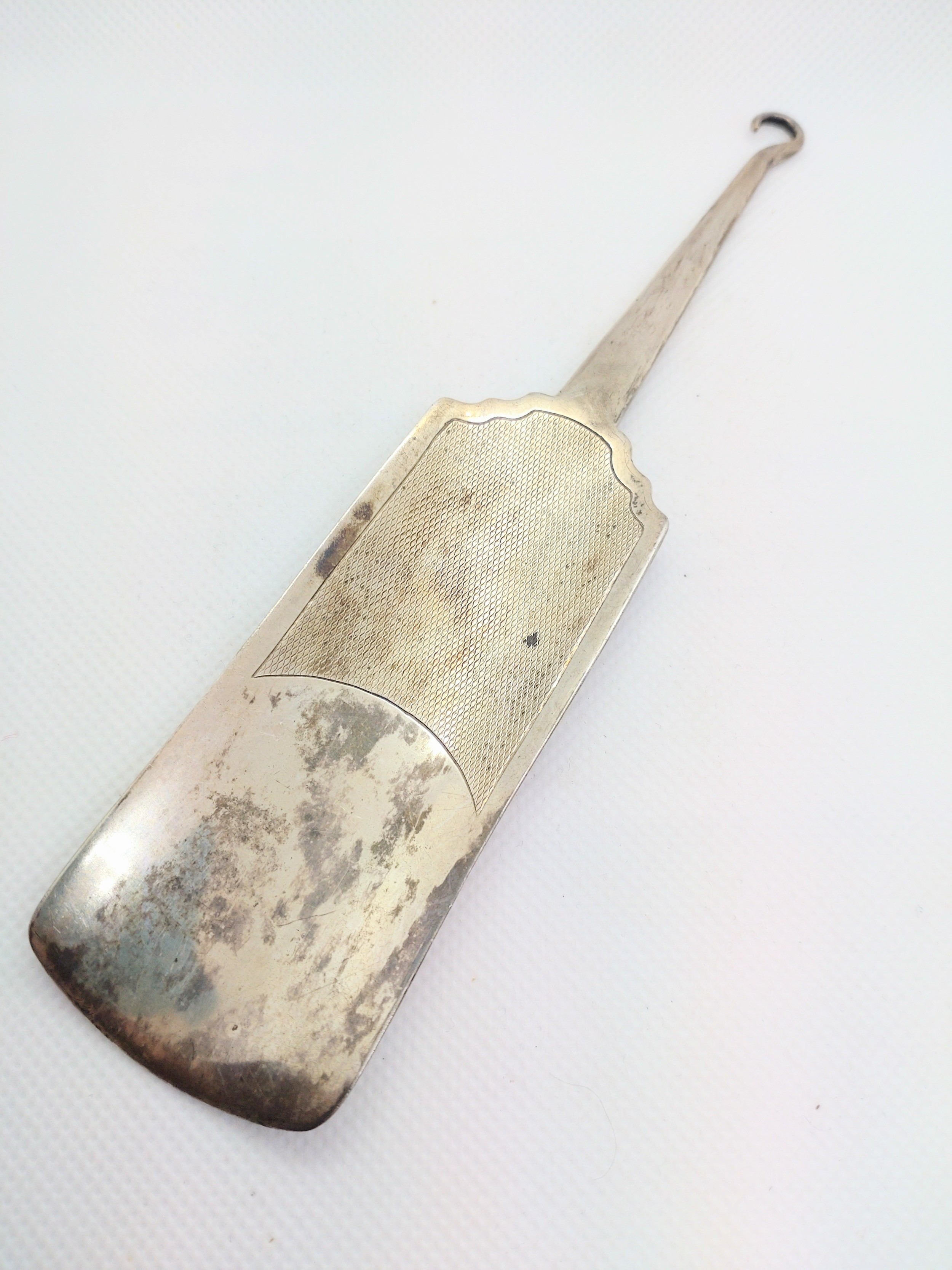 A sterling silver combination button hook shoehorn London 1937, with engine turned decoration.