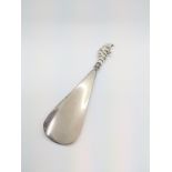 A Victorian shoehorn with a silver coloured metal terminal in the form of Punch. 15.5cm long