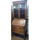 An Edwardian Oak Bureau Bookcase. The fall front opening to reveal a fitted interior. With a pair of