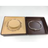 Two silver bracelets set with stones in a box.