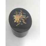 A black lacquered and gold pique oval box. 7cm wide.