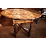 An Oak drop leaf table (extends to oval-shape), with barley twist legs and X stretcher. early 20th