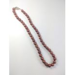 A necklace strung with chocolate freshwater pearls with a 9ct yellow and white gold oval clasp.