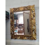 A modern decoratively carved mirror. 82 x 67cm