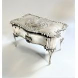 An Edwardian Jewellery Box. London 1902. In the form of a french desk. The top embossed with figures