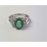 An 18ct white gold oval emerald and marquise diamond ornate cluster ring. Emerald 2.52ct. Diamonds