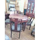 A Vintage Chinese Rosewood Circular Dining table and 10 chairs. Two of which are carvers.