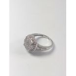 A diamond cluster ring set in 9ct white gold, with split shoulders. R/C diamonds 1.00ct. Size N.