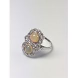 An unusual 18ct white gold Victorian ring set with two cabochan opals and several old European-cut