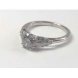 An 18ct white gold diamond solitaire ring set with Round Brilliant Cut and baguette cut diamond