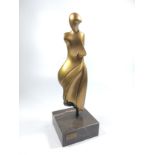 A modern art sculpture of a woman. 20th century. Gold patination.