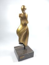 A modern art sculpture of a woman. 20th century. Gold patination.