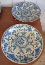 A pair of Chinese blue and white circular dishes, 35 diameter, one with rivet repair.