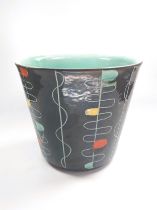 A black Gebruder Conradt plant pot with turquoise interior with black and silver makers label. 20.